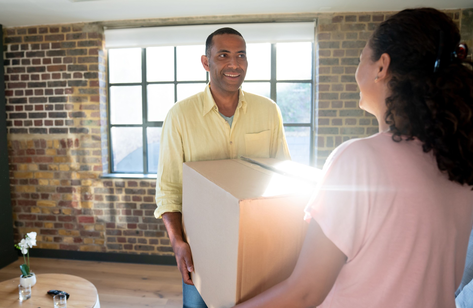 Happy black couple moving house and packing in boxes